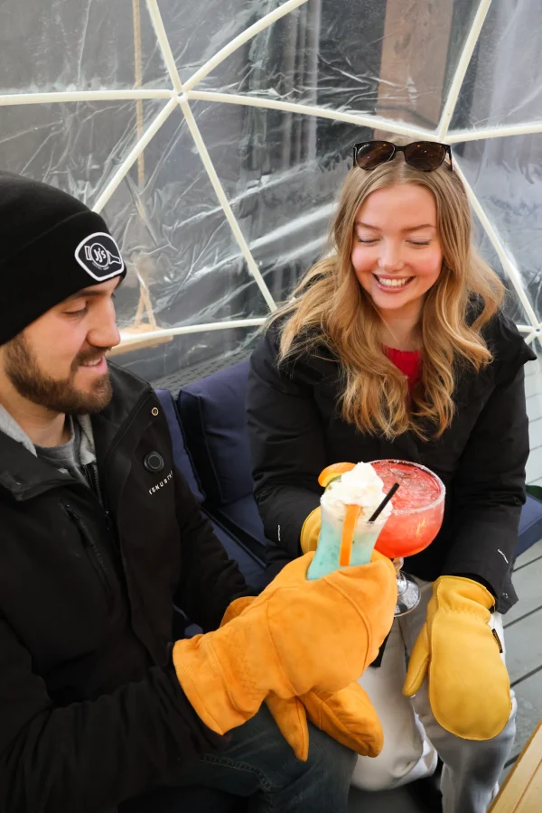 People smiling with orange cedar frost Saranac winter gloves